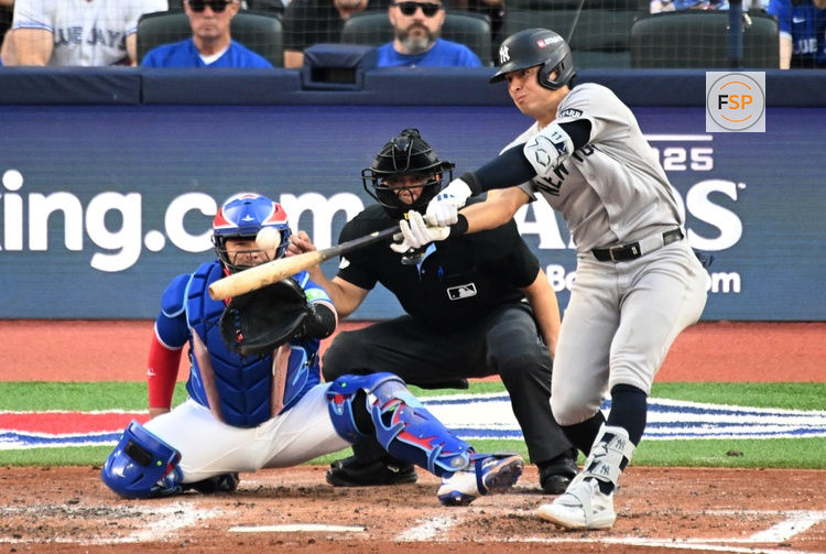 Oct 4, 2025; Toronto, Ontario, CAN; New York Yankees shortstop Anthony Volpe (11) doubles in the sixth inning in front of Toronto Blue Jays catcher Alejandro Kirk (30) during game one of the ALDS round for the 2025 MLB playoffs at Rogers Centre. Credit: Dan Hamilton-Imagn Images