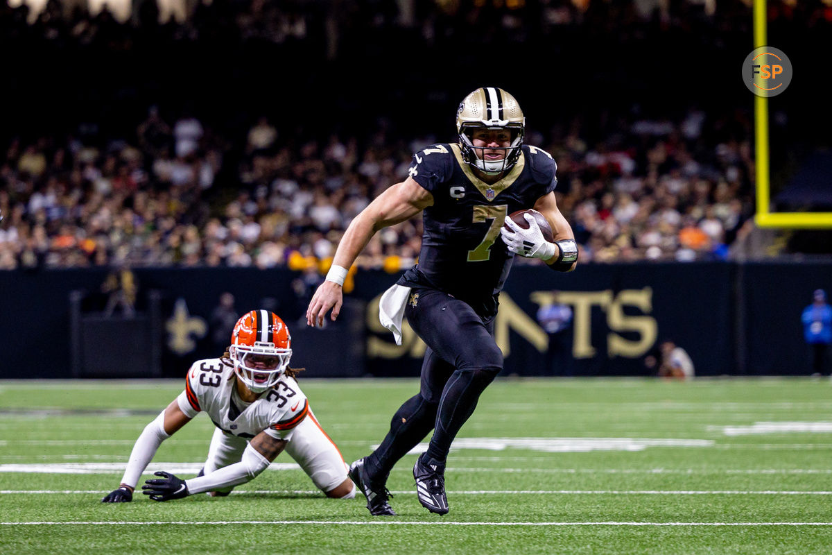 Nov 17, 2024; New Orleans, Louisiana, USA;  New Orleans Saints tight end Taysom Hill (7) avoids the tackle of Cleveland Browns safety Ronnie Hickman (33) during the second half at Caesars Superdome. Credit: Stephen Lew-Imagn Images