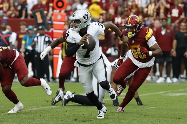 Sep 21, 2025; Landover, Maryland, USA; Las Vegas Raiders quarterback Geno Smith (7) scrambles from Washington Commanders defensive end Javontae Jean-Baptiste (90) during the third quarter at Northwest Stadium. Mandatory Credit: Geoff Burke-Imagn Images