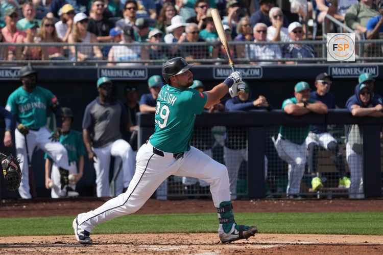 Feb 26, 2026; Peoria, Arizona, USA; Seattle Mariners catcher Cal Raleigh (29) hits an RBI sacrifice fly out against the Cleveland Guardians in the second inning at Peoria Sports Complex. Credit: Rick Scuteri-Imagn Images