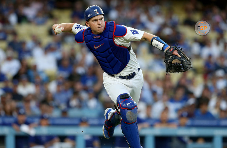 Jul 23, 2024; Los Angeles, California, USA; Los Angeles Dodgers catcher Will Smith (16) throws to first for an out during the second inning against the San Francisco Giants at Dodger Stadium. Credit: Jason Parkhurst-USA TODAY Sports