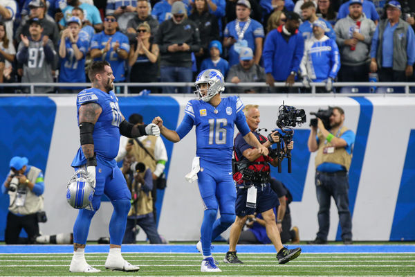 DETROIT, MI - OCTOBER 08:  Detroit Lions quarterback Jared Goff (16) fist bumps Detroit Lions offensive tackle Taylor Decker (68) as they walk to the sideline after a touchdown during the first quarter of an NFL football game between the Carolina Panthers and the Detroit Lions on October 8, 2023 at Ford Field in Detroit, Michigan.  (Photo by Scott W. Grau/Icon Sportswire)