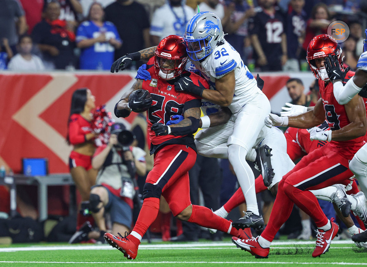 Nov 10, 2024; Houston, Texas, USA; Houston Texans running back Joe Mixon (28) runs with the ball as Detroit Lions safety Brian Branch (32) attempts to make a tackle during the first quarter at NRG Stadium. Credit: Troy Taormina-Imagn Images