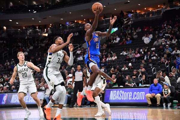 Oct 14, 2025; Milwaukee, Wisconsin, USA; Oklahoma City Thunder guard Cason Wallace (22) goes up for a shot against Milwaukee Bucks forward Giannis Antetokounmpo (34) during the second half at Fiserv Forum. Mandatory Credit: Patrick Gorski-Imagn Images