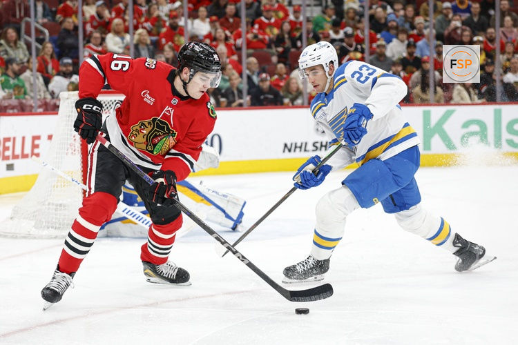Apr 11, 2026; Chicago, Illinois, USA; Chicago Blackhawks center Anton Frondell (16) battles for the puck with St. Louis Blues defenseman Logan Mailloux (23) during the first period at United Center. Credit: Kamil Krzaczynski-Imagn Images