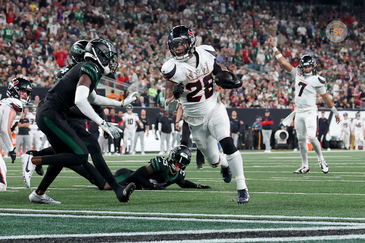 Oct 31, 2024; East Rutherford, New Jersey, USA; Houston Texans running back Joe Mixon (28) runs for a touchdown against New York Jets cornerback Sauce Gardner (1) and safety Jalen Mills (35) during the second quarter at MetLife Stadium. Credit: Brad Penner-Imagn Images