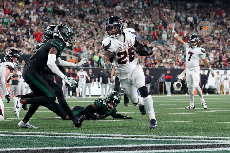 Oct 31, 2024; East Rutherford, New Jersey, USA; Houston Texans running back Joe Mixon (28) runs for a touchdown against New York Jets cornerback Sauce Gardner (1) and safety Jalen Mills (35) during the second quarter at MetLife Stadium. Credit: Brad Penner-Imagn Images