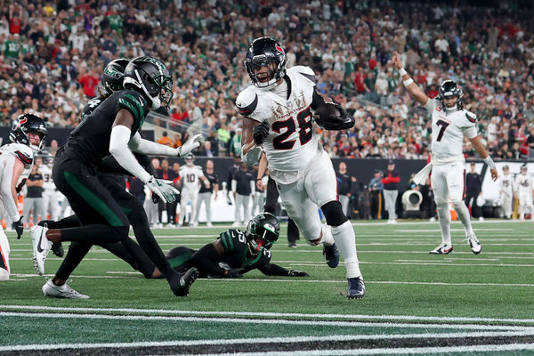 Oct 31, 2024; East Rutherford, New Jersey, USA; Houston Texans running back Joe Mixon (28) runs for a touchdown against New York Jets cornerback Sauce Gardner (1) and safety Jalen Mills (35) during the second quarter at MetLife Stadium. Mandatory Credit: Brad Penner-Imagn Images