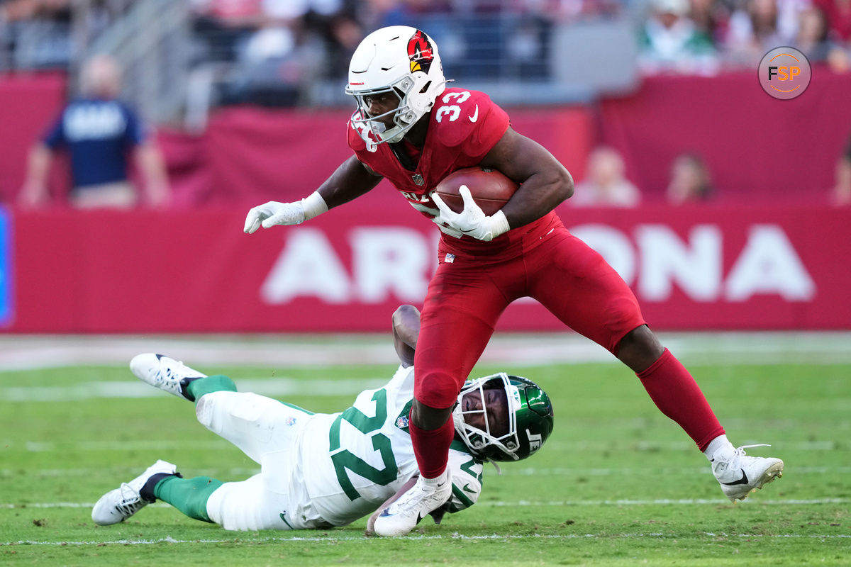 Nov 10, 2024; Glendale, Arizona, USA; Arizona Cardinals running back Trey Benson (33) runs by New York Jets safety Tony Adams (22) during the first half at State Farm Stadium. Credit: Joe Camporeale-Imagn Images