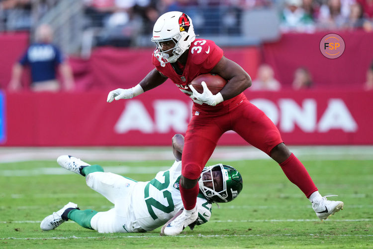 Nov 10, 2024; Glendale, Arizona, USA; Arizona Cardinals running back Trey Benson (33) runs by New York Jets safety Tony Adams (22) during the first half at State Farm Stadium. Credit: Joe Camporeale-Imagn Images