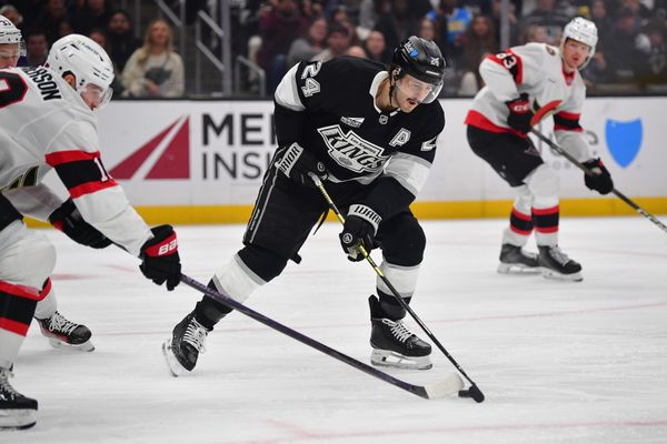 Nov 24, 2025; Los Angeles, California, USA; Los Angeles Kings center Phillip Danault (24) plays for the puck against Ottawa Senators center Tim Stutzle (18) during the second period at Crypto.com Arena. Mandatory Credit: Gary A. Vasquez-Imagn Images