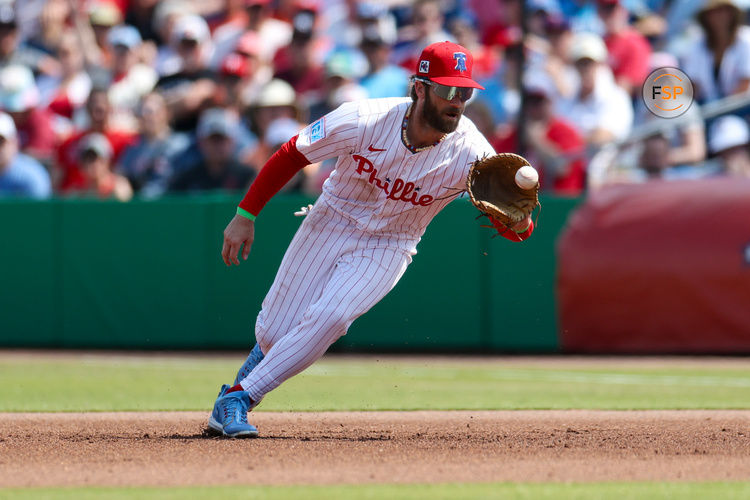 Mar 9, 2025; Clearwater, Florida, USA; Philadelphia Phillies first baseman Bryce Harper (3) fields the ball against the Baltimore Orioles in the fifth inning during spring trining at BayCare Ballpark. Credit: Nathan Ray Seebeck-Imagn Images