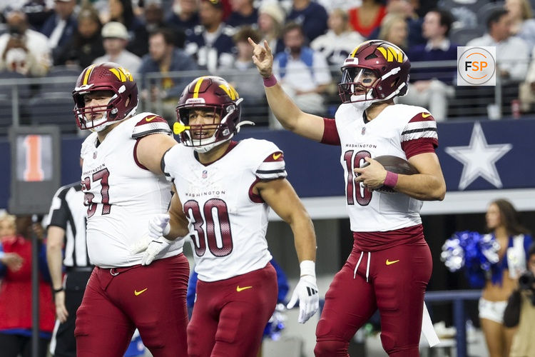 Jan 5, 2025; Arlington, Texas, USA;  Washington Commanders quarterback Marcus Mariota (18) celebrates with teammates after scoring a touchdown  during the second half at AT&T Stadium. Credit: Kevin Jairaj-Imagn Images
