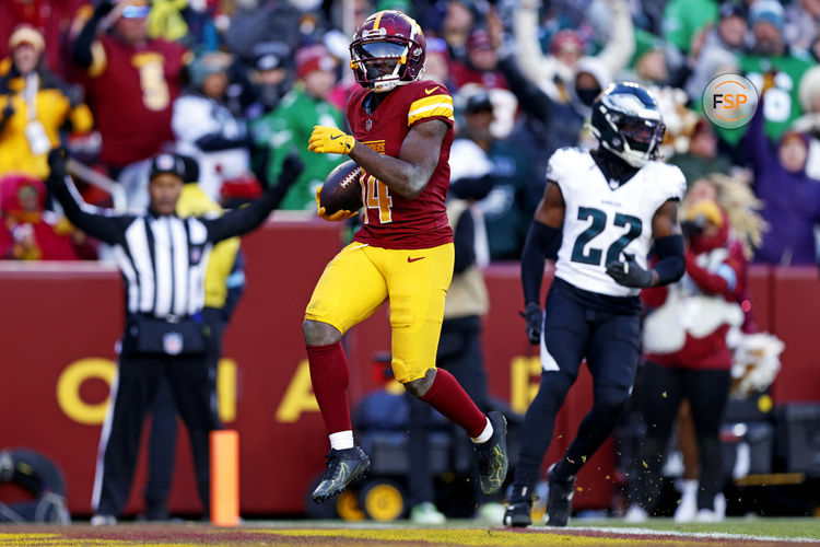 Dec 22, 2024; Landover, Maryland, USA; Washington Commanders wide receiver Olamide Zaccheaus (14) scores a touchdown during the fourth quarter against the Philadelphia Eagles at Northwest Stadium. Credit: Peter Casey-Imagn Images