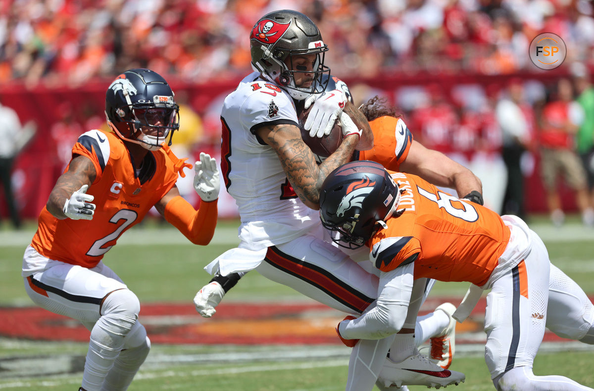 Sep 22, 2024; Tampa, Florida, USA; Denver Broncos safety P.J. Locke (6), cornerback Pat Surtain II (2) and linebacker Alex Singleton (49) tackle Tampa Bay Buccaneers wide receiver Mike Evans (13) after a reception during the first half at Raymond James Stadium. Credit: Kim Klement Neitzel-Imagn Images