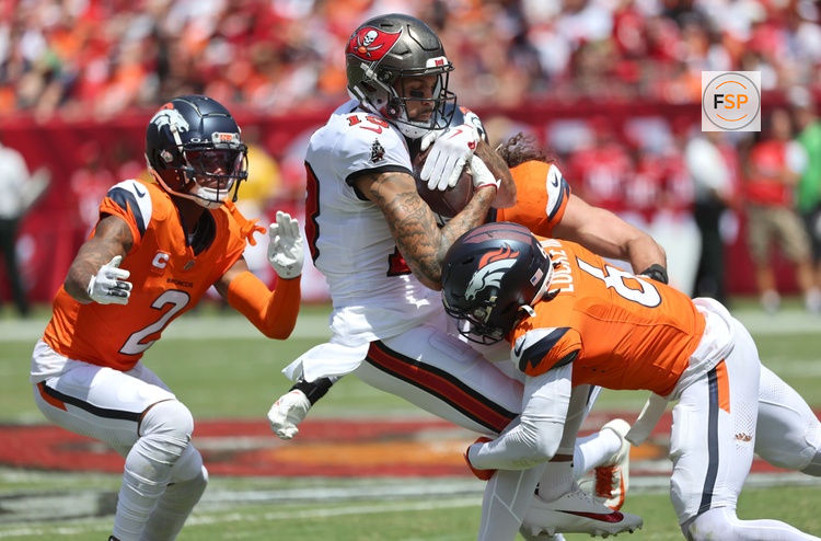 Sep 22, 2024; Tampa, Florida, USA; Denver Broncos safety P.J. Locke (6), cornerback Pat Surtain II (2) and linebacker Alex Singleton (49) tackle Tampa Bay Buccaneers wide receiver Mike Evans (13) after a reception during the first half at Raymond James Stadium. Credit: Kim Klement Neitzel-Imagn Images