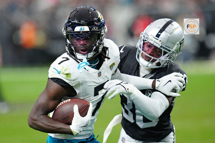 Dec 22, 2024; Paradise, Nevada, USA; Las Vegas Raiders cornerback Darnay Holmes (30) looks to knock the ball away from Jacksonville Jaguars wide receiver Brian Thomas Jr. (7) during the second quarter at Allegiant Stadium. Credit: Stephen R. Sylvanie-Imagn Images