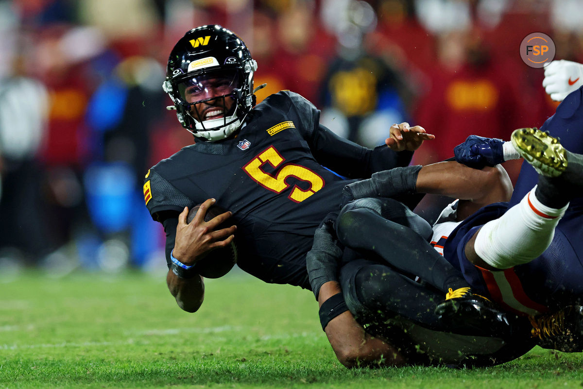 Oct 27, 2024; Landover, Maryland, USA; Washington Commanders quarterback Jayden Daniels (5) reaches for a first down but is short during the fourth quarter against the Chicago Bears at Commanders Field. Credit: Peter Casey-Imagn Images