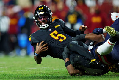 Oct 27, 2024; Landover, Maryland, USA; Washington Commanders quarterback Jayden Daniels (5) reaches for a first down but is short during the fourth quarter against the Chicago Bears at Commanders Field. Mandatory Credit: Peter Casey-Imagn Images