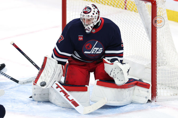 Feb 7, 2025; Winnipeg, Manitoba, CAN; Winnipeg Jets goaltender Connor Hellebuyck (37) makes a blocker save against the New York Islanders in the third period at Canada Life Centre. Credit: James Carey Lauder-Imagn Images