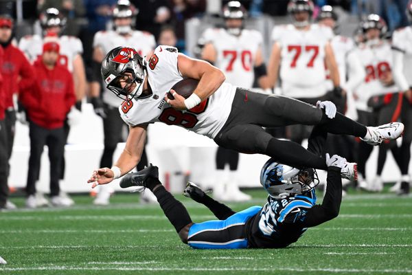 Dec 1, 2024; Charlotte, North Carolina, USA; Tampa Bay Buccaneers tight end Cade Otton (88) is tackled by Carolina Panthers cornerback Chau Smith-Wade (26) in overtime at Bank of America Stadium. Mandatory Credit: Bob Donnan-Imagn Images