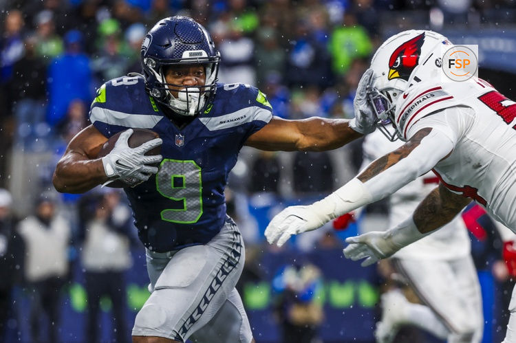 Nov 24, 2024; Seattle, Washington, USA; Seattle Seahawks running back Kenneth Walker III (9) stiff-arms away from a tackle attempt by Arizona Cardinals linebacker Xavier Thomas (54) after catching a pass during the fourth quarter at Lumen Field. Credit: Joe Nicholson-Imagn Images