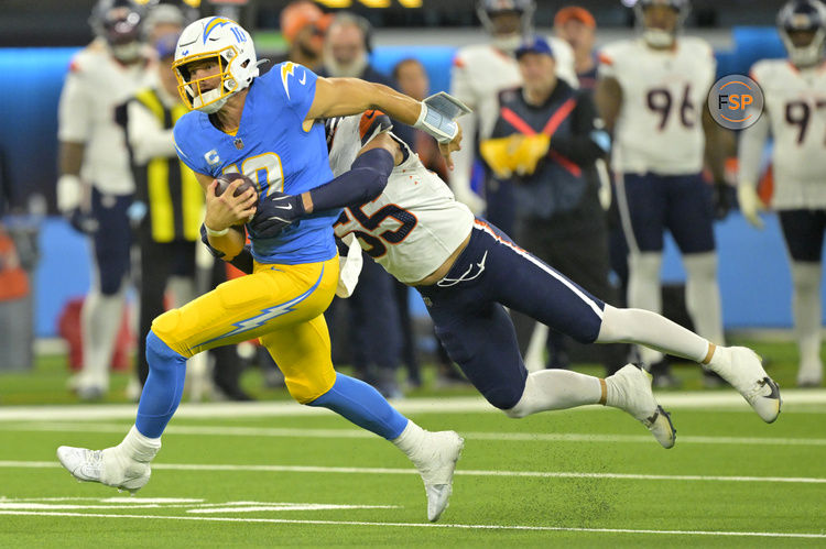 Dec 19, 2024; Inglewood, California, USA;  Los Angeles Chargers quarterback Justin Herbert (10) is brought down by Denver Broncos linebacker Cody Barton (55) after an 18-yard run in the second half at SoFi Stadium. Credit: Jayne Kamin-Oncea-Imagn Images