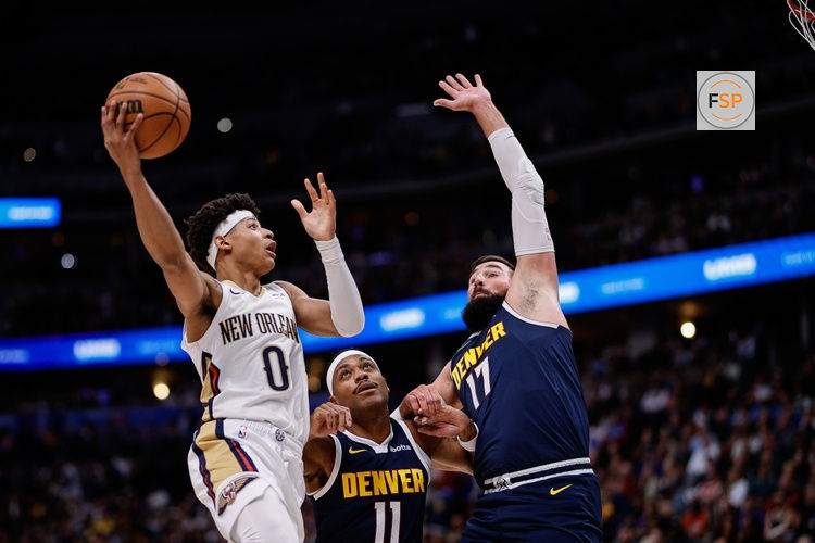 Oct 29, 2025; Denver, Colorado, USA; New Orleans Pelicans guard Jeremiah Fears (0) drives to the net against Denver Nuggets guard Bruce Brown (11) and center Jonas Valanciunas (17) in the second quarter at Ball Arena. Credit: Isaiah J. Downing-Imagn Images