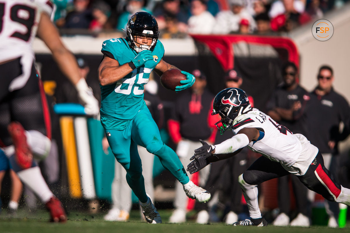 Dec 1, 2024; Jacksonville, Florida, USA; Jacksonville Jaguars tight end Brenton Strange (85) runs after the catch against Houston Texans cornerback Kamari Lassiter (4) in the third quarter  at EverBank Stadium. Credit: Jeremy Reper-Imagn Images