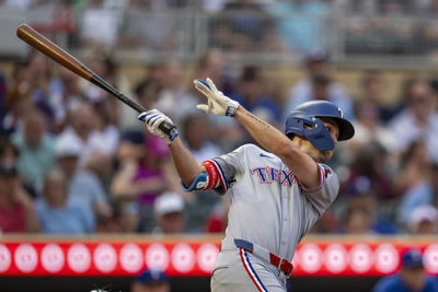 Jun 10, 2025; Minneapolis, Minnesota, USA; Texas Rangers center fielder Evan Carter (32) hits a single against the Minnesota Twins in the fifth inning at Target Field. Mandatory Credit: Jesse Johnson-Imagn Images