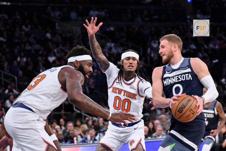 Oct 9, 2025; New York, New York, USA; Minnesota Timberwolves guard Donte Divincenzo tries to get past New York Knicks center/forward Mitchell Robinson (23) and guard Jordan Clarkson (00) during the first half at Madison Square Garden. Credit: John Jones-Imagn Images
