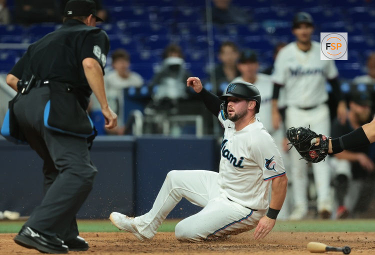 Mar 31, 2026; Miami, Florida, USA; Miami Marlins first baseman Liam Hicks (34) slides at home plate and scores against the Chicago White Sox during the eighth inning at loanDepot Park. Credit: Sam Navarro-Imagn Images