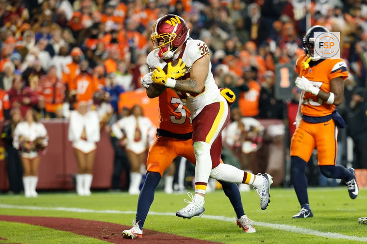 Nov 30, 2025; Landover, Maryland, USA; Washington Commanders running back Chris Rodriguez Jr. (36) scores a touchdown defended by Denver Broncos cornerback Kris Abrams-Draine (31) in the second quarter of the game at Northwest Stadium. Credit: Geoff Burke-Imagn Images