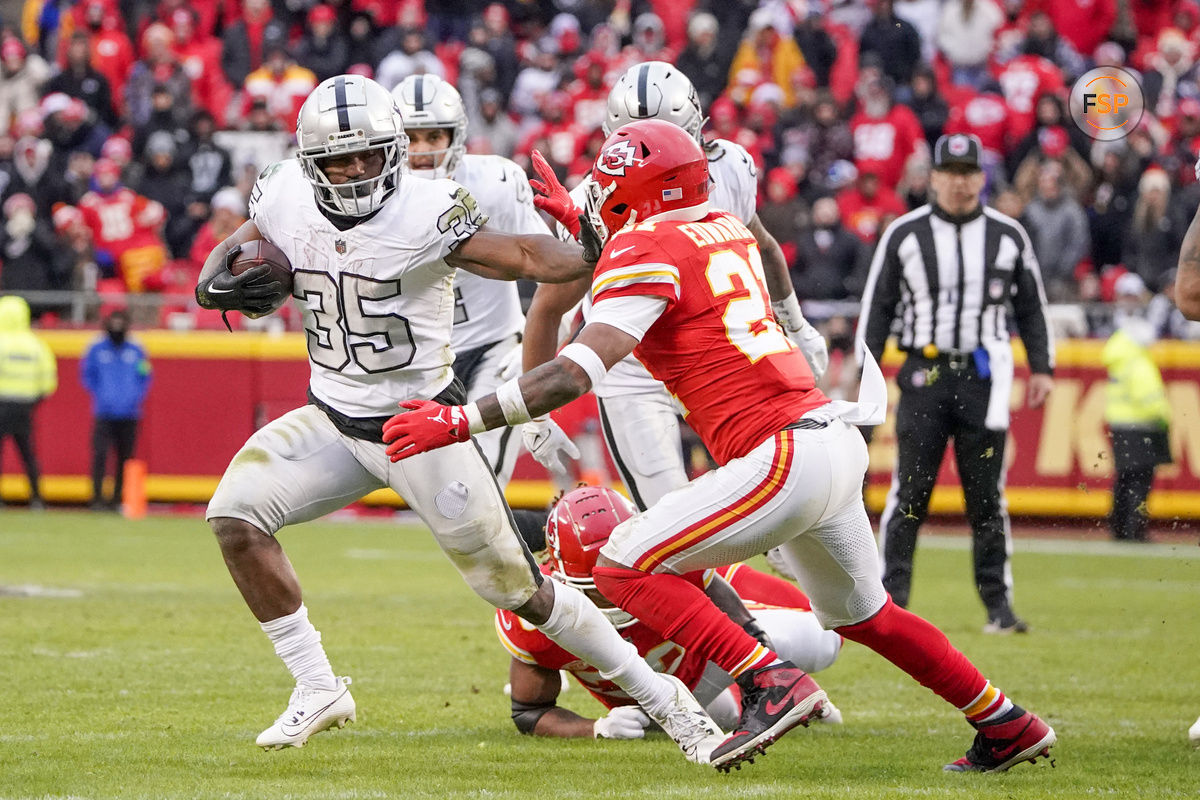 Dec 25, 2023; Kansas City, Missouri, USA; Las Vegas Raiders running back Zamir White (35) runs the ball as Kansas City Chiefs safety Mike Edwards (21) attempts the tackle during the second half at GEHA Field at Arrowhead Stadium. Credit: Denny Medley-USA TODAY Sports