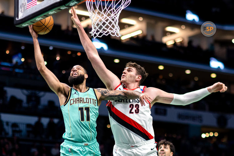 Jan 24, 2025; Charlotte, North Carolina, USA; Charlotte Hornets forward Cody Martin (11) shoots around Portland Trail Blazers center Donovan Clingan (23) during the first quarter at Spectrum Center. Credit: Scott Kinser-Imagn Images