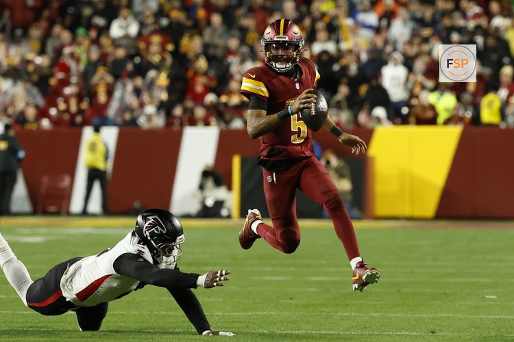 Dec 29, 2024; Landover, Maryland, USA; Washington Commanders quarterback Jayden Daniels (5) runs with the ball as Atlanta Falcons tight end Kyle Pitts (8) attempts a tackle during the third quarter at Northwest Stadium. Credit: Geoff Burke-Imagn Images