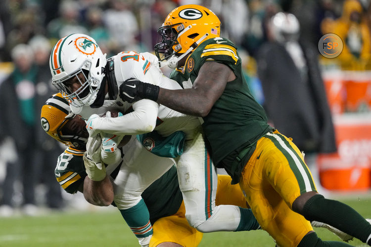 Nov 28, 2024; Green Bay, Wisconsin, USA;  Miami Dolphins wide receiver Jaylen Waddle (17) is tackled by Green Bay Packers linebacker Isaiah McDuffie (58) and linebacker Quay Walker (7) during the fourth quarter at Lambeau Field. Credit: Jeff Hanisch-Imagn Images