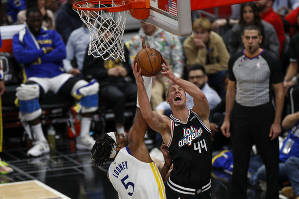 LOS ANGELES, CA - FEBRUARY 14:  LA Clippers center Mason Plumlee attempts to the shoot ball against Golden State Warriors forward Kevon Looney (5) during an NBA game on February 14, 2023 at Crypto.com Arena in Los Angeles, CA. (Photo by Brandon Sloter/Icon Sportswire)