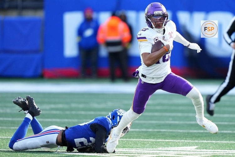 Dec 21, 2025; East Rutherford, New Jersey, USA; Minnesota Vikings wide receiver Justin Jefferson (18) makes a catch against New York Giants cornerback Paulson Adebo (21) during the first half at MetLife Stadium. Credit: Robert Deutsch-Imagn Images