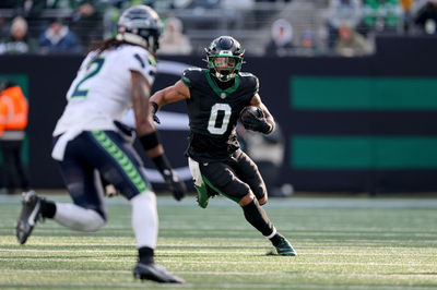 Dec 1, 2024; East Rutherford, New Jersey, USA; New York Jets running back Braelon Allen (0) carries the ball asSeattle Seahawks safety Rayshawn Jenkins (2) defends during the first quarter at MetLife Stadium. Mandatory Credit: Vincent Carchietta-Imagn Images