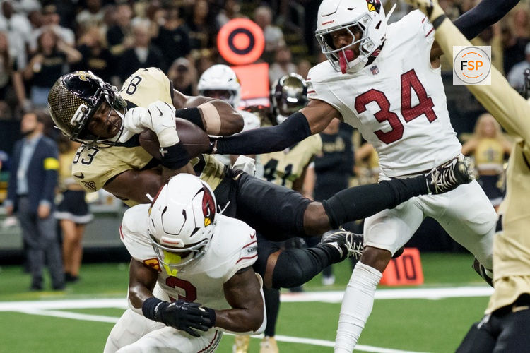 Sep 7, 2025; New Orleans, Louisiana, USA; New Orleans Saints tight end Juwan Johnson (83) grabs a pass in the end zone but Arizona Cardinals safety Jalen Thompson (34) knocks the ball loose in for an incomplete pass during the fourth quarter at Caesars Superdome. Credit: Matthew Hinton-Imagn Images