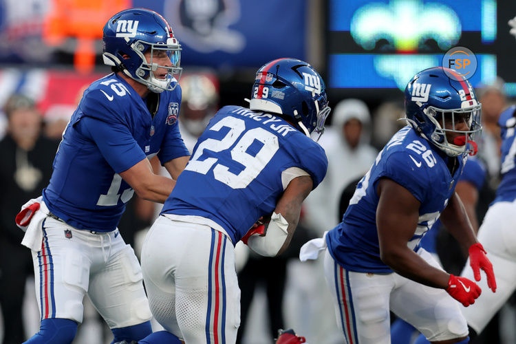 Dec 8, 2024; East Rutherford, New Jersey, USA; New York Giants quarterback Tommy DeVito (15) hands off to running back Tyrone Tracy Jr. (29) during the fourth quarter against the New Orleans Saints at MetLife Stadium. Credit: Brad Penner-Imagn Images