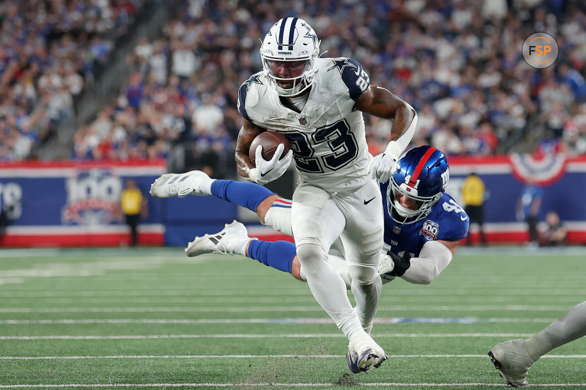 Sep 26, 2024; East Rutherford, New Jersey, USA; Dallas Cowboys running back Rico Dowdle (23) runs for a touchdown against New York Giants linebacker Micah McFadden (41) during the first quarter at MetLife Stadium. Credit: Brad Penner-Imagn Images