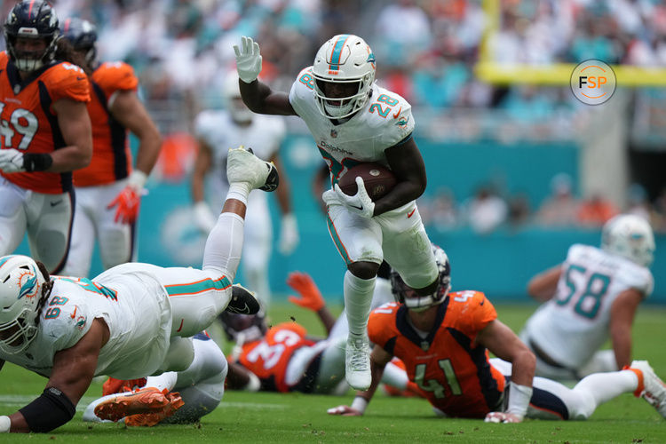 MIAMI GARDENS, FL - SEPTEMBER 24: Miami Dolphins running back De'Von Achane (28) jumps over tacklers as he rushes during the game between the Denver Broncos and the Miami Dolphins on Sunday, September 24, 2023 at Hard Rock Stadium, Miami, Fla. (Photo by Peter Joneleit/Icon Sportswire)