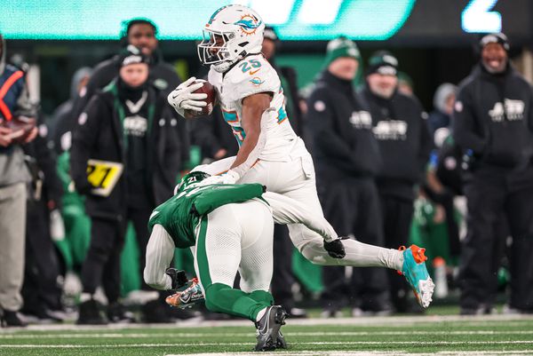 Jan 5, 2025; East Rutherford, New Jersey, USA; Miami Dolphins running back Jaylen Wright (25) fights for yards  as New York Jets safety Ashtyn Davis (21) tackles during the second half at MetLife Stadium. Mandatory Credit: Vincent Carchietta-Imagn Images