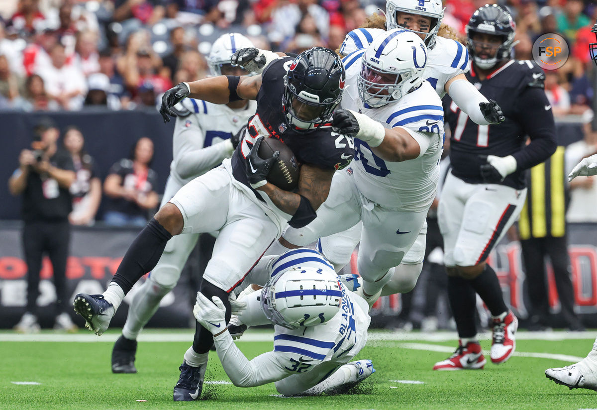 Oct 27, 2024; Houston, Texas, USA; Houston Texans running back Joe Mixon (28) runs with the ball as Indianapolis Colts defensive tackle Grover Stewart (90) and safety Julian Blackmon (32) attempt to make a tackle during the third quarter at NRG Stadium. Credit: Troy Taormina-Imagn Images