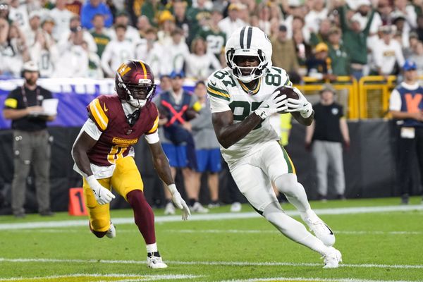 Sep 11, 2025; Green Bay, Wisconsin, USA; Green Bay Packers wide receiver Romeo Doubs (87) scores a touchdown against Washington Commanders cornerback Mike Sainristil (0) in the first quarter at Lambeau Field. Mandatory Credit: Jeff Hanisch-Imagn Images
