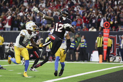 Jan 11, 2025; Houston, Texas, USA;  Houston Texans wide receiver Nico Collins (12) scores a touchdown against the Los Angeles Chargers in the second quarter in an AFC wild card game at NRG Stadium. Mandatory Credit: Thomas Shea-Imagn Images