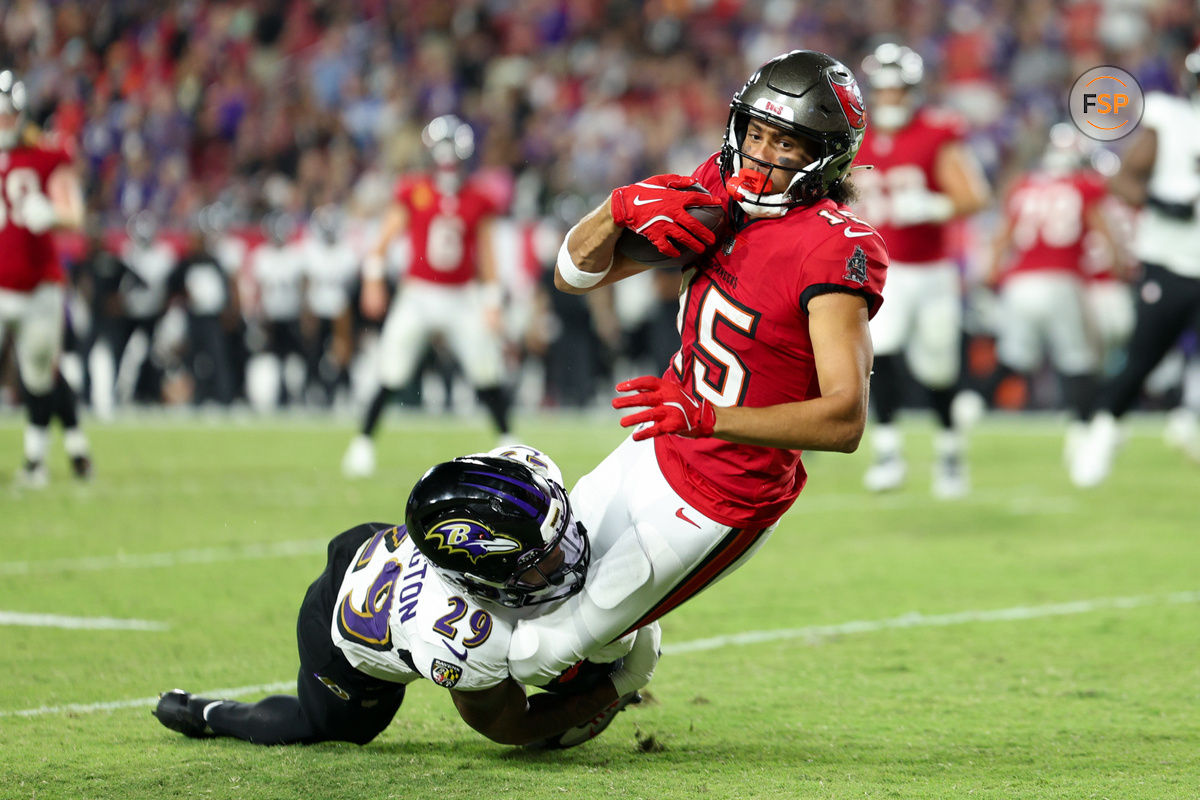 Oct 21, 2024; Tampa, Florida, USA; Tampa Bay Buccaneers wide receiver Jalen McMillan (15) is tackled by Baltimore Ravens safety Ar'Darius Washington (29) in the fourth quarter at Raymond James Stadium. Credit: Nathan Ray Seebeck-Imagn Images