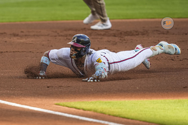 May 20, 2024; Cumberland, Georgia, USA; Atlanta Braves right fielder Ronald Acuna Jr (13) slides into third base after hitting a triple against the San Diego Padres during the first inning at Truist Park. Credit: Dale Zanine-USA TODAY Sports